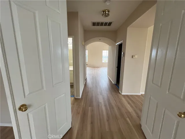 a view of a hallway with wooden floor