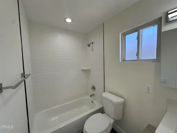 a bathroom with a toilet and a bath tub