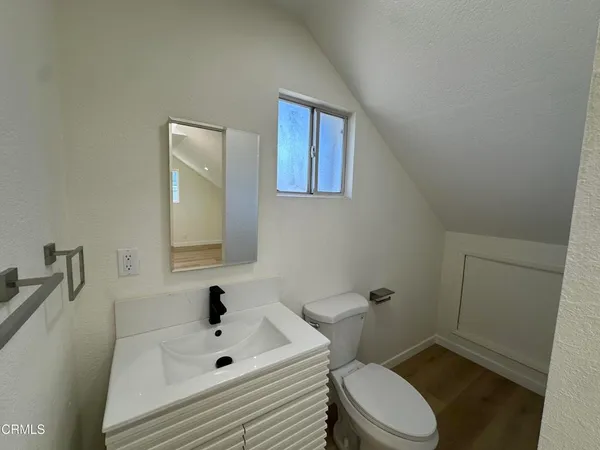 a bathroom with a sink mirror vanity and toilet