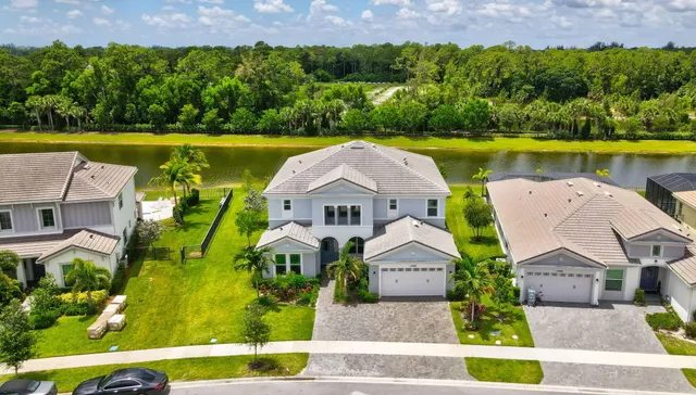 an aerial view of a house with a swimming pool a yard and lake view