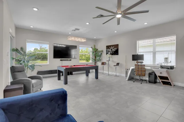 a large bedroom with bed and a flat tv screen on dresser