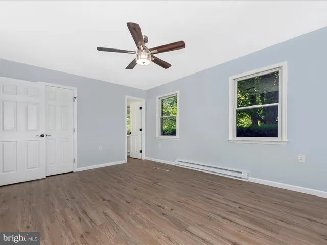 a view of a room with wooden floor and a ceiling fan