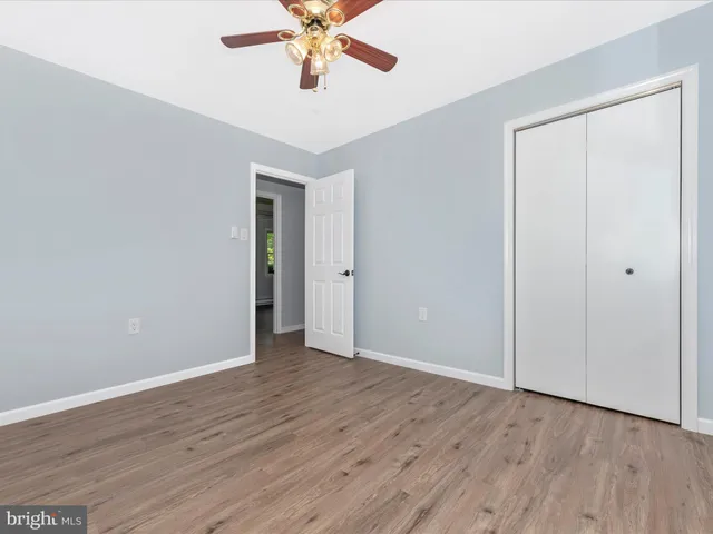 a bathroom with a granite countertop toilet sink mirror and vanity