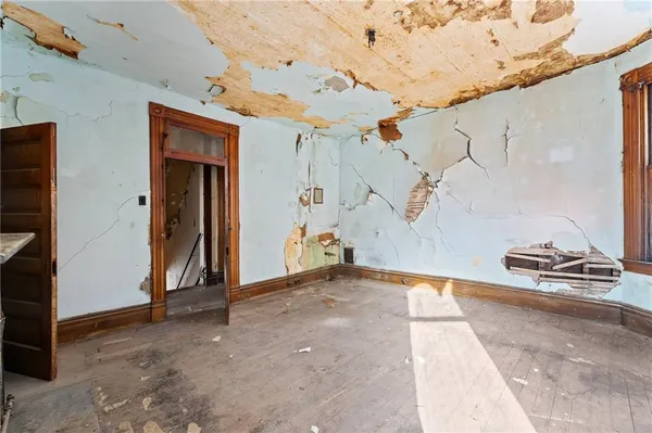 a view of an empty room with furniture and a window