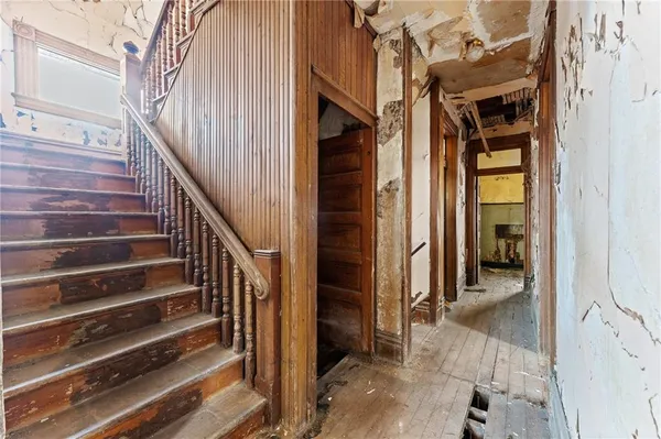 a view of a hallway with wooden floor and entryway