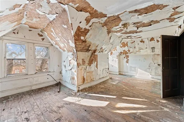 a view of a room with wooden floor and white walls