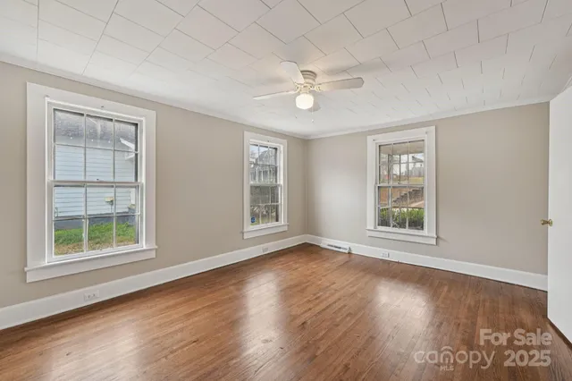 a view of a room with wooden floor and windows