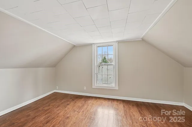 a view of a big room with wooden floor and windows