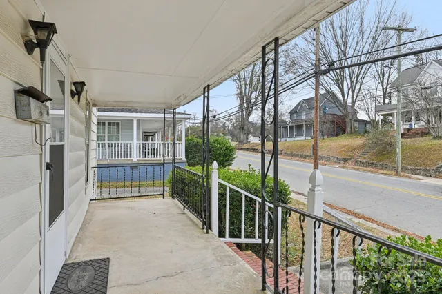an empty room with wooden floor ceiling fan and windows