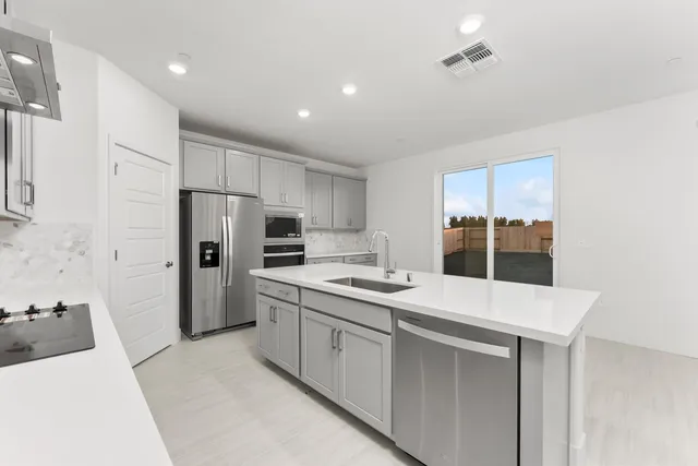 a kitchen with a sink a refrigerator and a stove