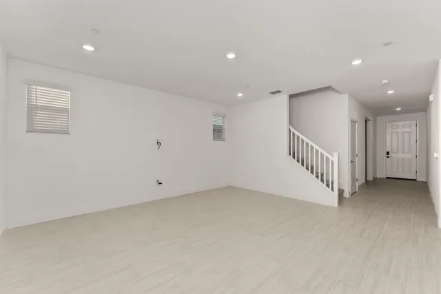 an empty room with staircase and windows