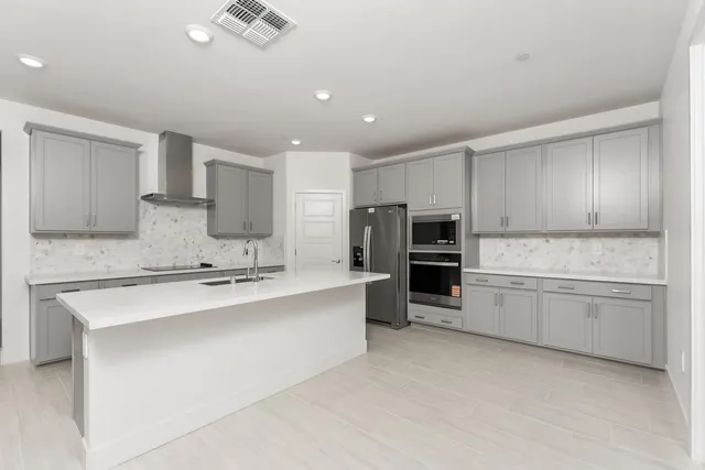 a large kitchen with a stove top oven a sink and dishwasher a oven with white cabinets