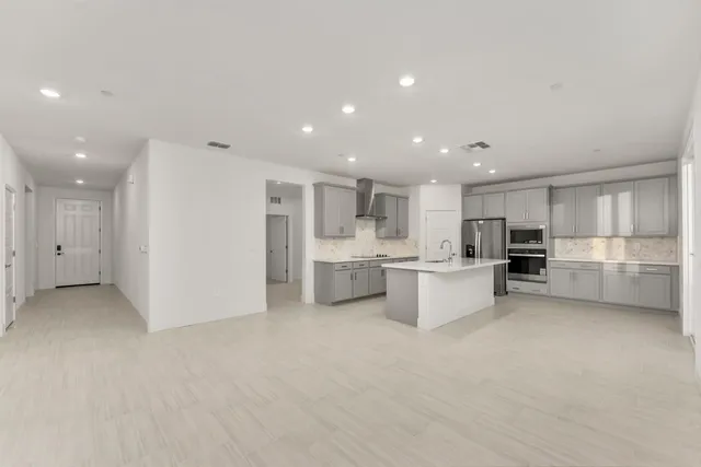 a view of kitchen with stainless steel appliances kitchen island a white stove top oven and white cabinets