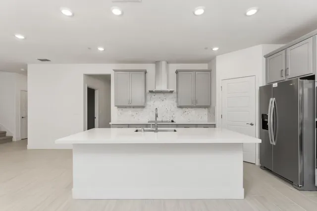 a large kitchen with stainless steel appliances granite countertop a refrigerator a sink and a stove