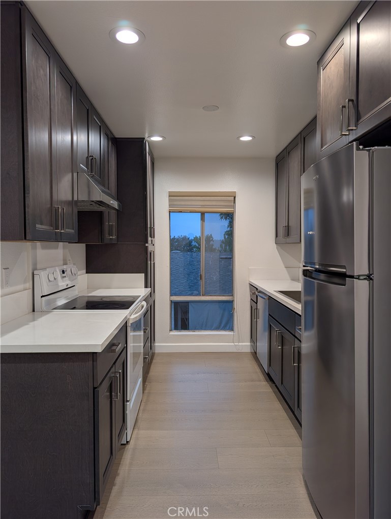 17052 Colima Road, Unit 206 Hacienda Heights, CA 91745 - Photo 3 of 15 a kitchen with stainless steel appliances granite countertop a sink a stove and a refrigerator