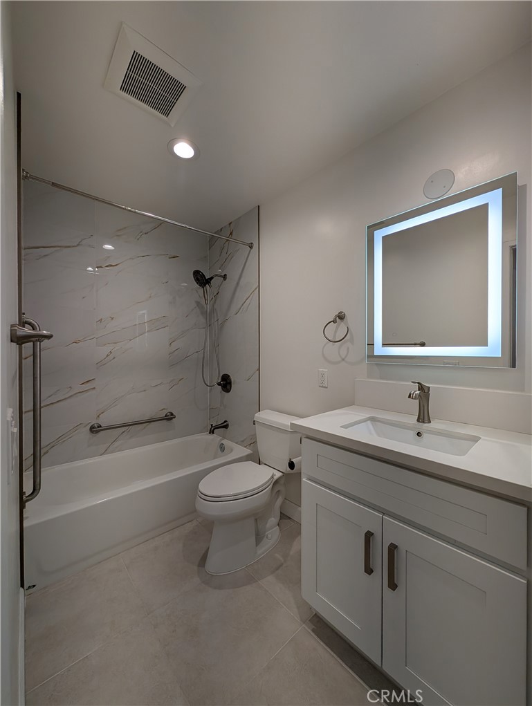 17052 Colima Road, Unit 206 Hacienda Heights, CA 91745 - Photo 7 of 15 a bathroom with a toilet a sink a mirror a bathtub and vanity