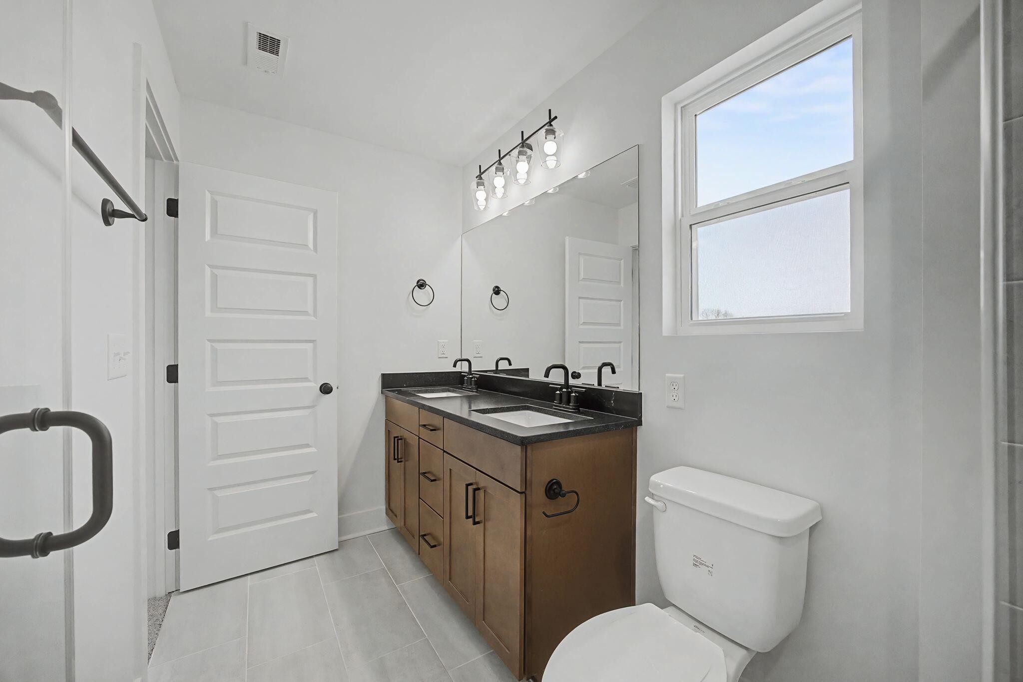 1616 Cotton Way Chattanooga, TN 37404 - Photo 27 of 38 a bathroom with a granite countertop sink toilet a mirror and shower