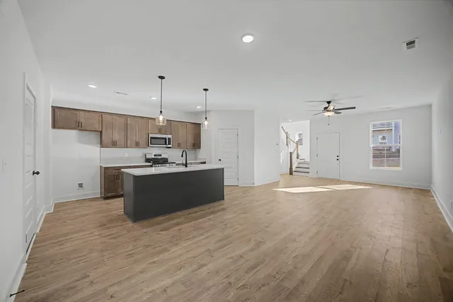 a large kitchen with kitchen island a sink stainless steel appliances and cabinets
