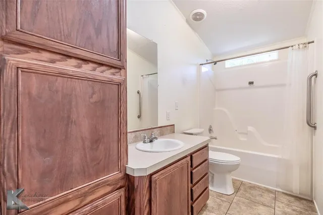 a bathroom with a granite countertop sink toilet a shower and a mirror