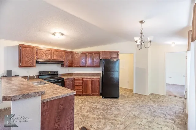 a kitchen with stainless steel appliances granite countertop a refrigerator a stove a sink dishwasher and microwave with wooden floor