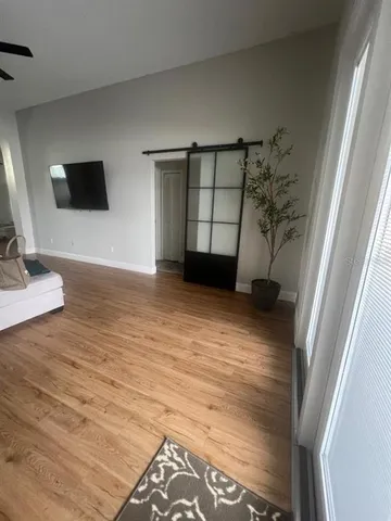 a view of empty room with window and wooden floor