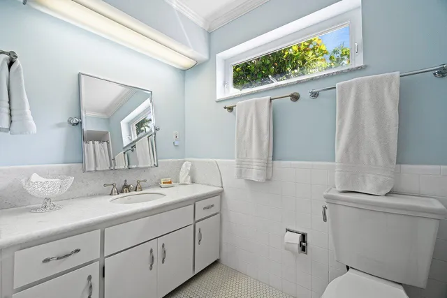 a bathroom with a toilet sink and mirror