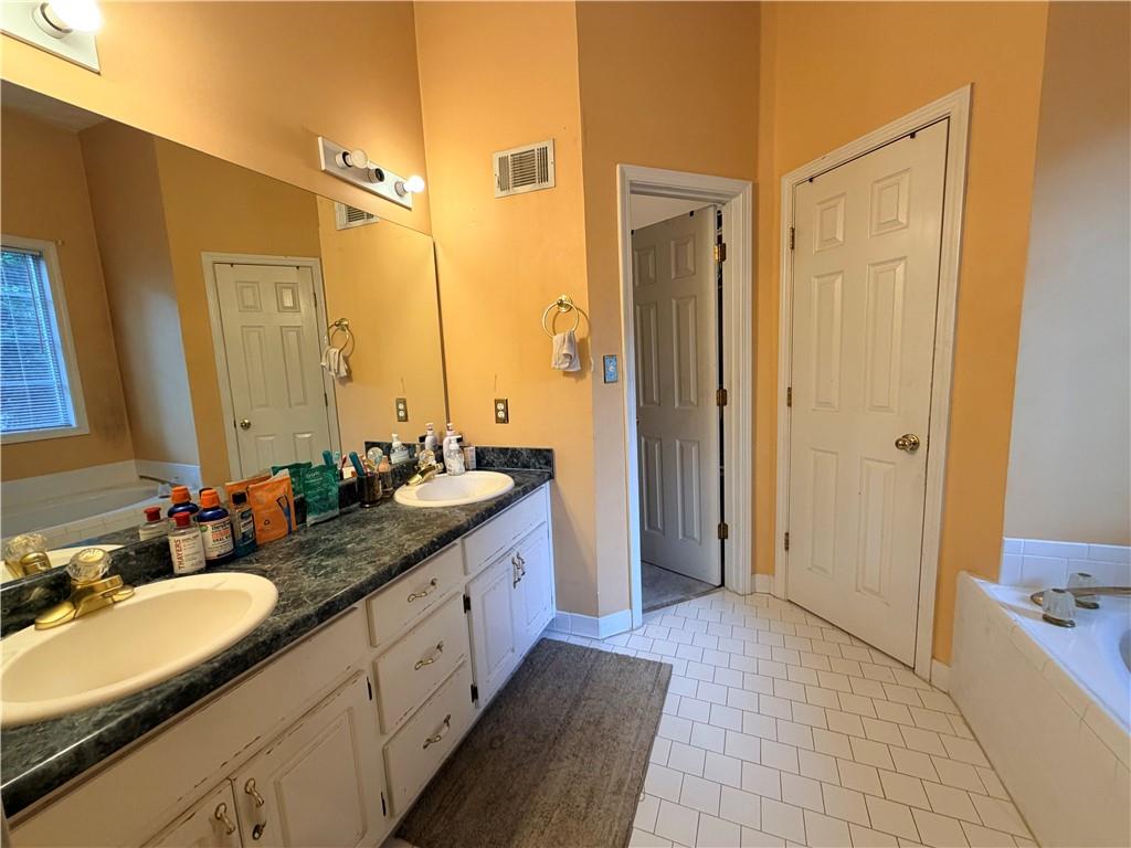 426 Pates Lake Court Hampton, GA 30228 - Photo 32 of 60 a spacious bathroom with a double vanity sink a mirror and a shower