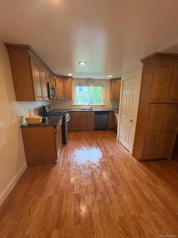 a kitchen with stainless steel appliances granite countertop a stove a sink and a refrigerator