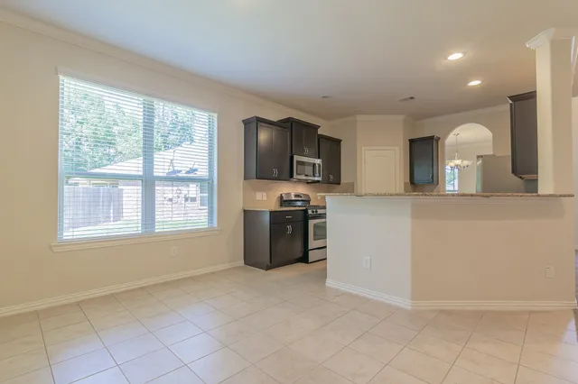 a large kitchen with granite countertop a stove a sink a refrigerator and a granite counter tops