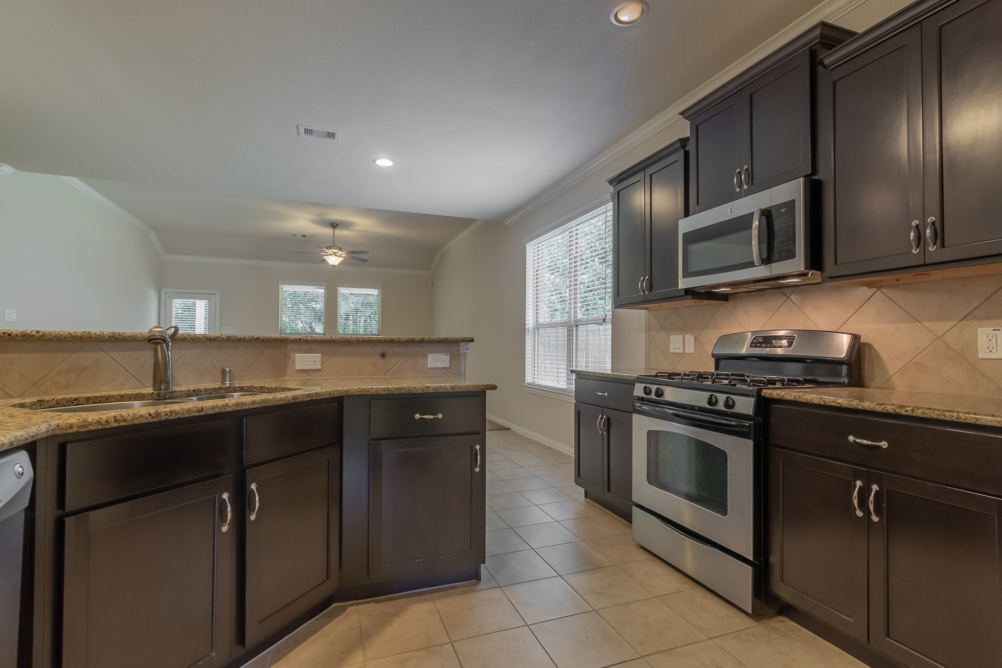 5 Iris Arbor Court Conroe, TX 77301 - Photo 2 of 35 a kitchen with stainless steel appliances granite countertop a stove a sink dishwasher and a microwave