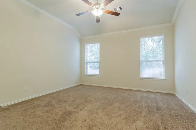 an empty room with a ceiling fan and a window