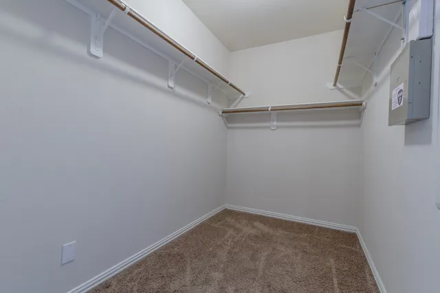 an empty room with a fan & a window