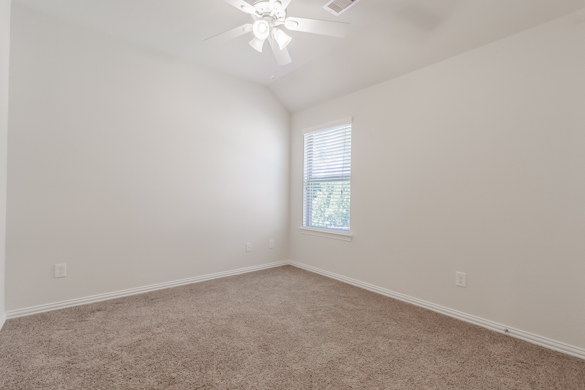 5 Iris Arbor Court Conroe, TX 77301 - Photo 33 of 35 an empty room with windows and chandelier fan