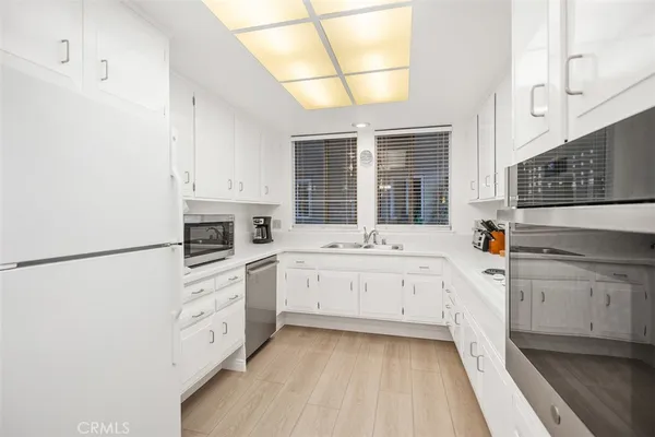a kitchen with white cabinets and white appliances