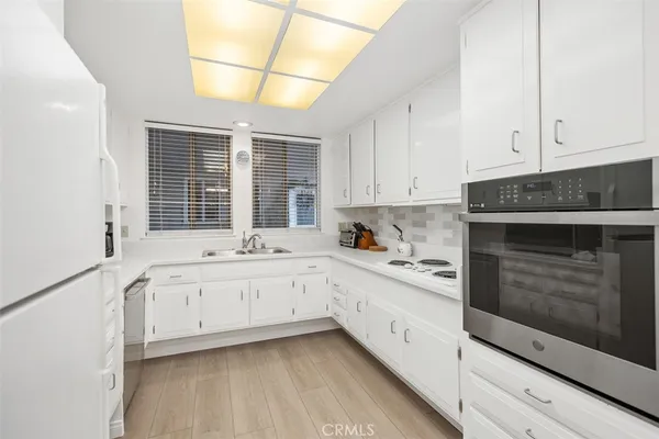 a kitchen with granite countertop white cabinets and white appliances