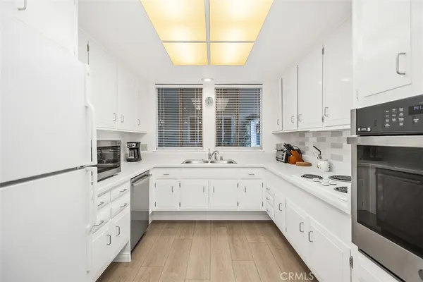 a kitchen with granite countertop white cabinets and white appliances