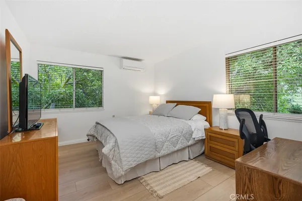 a bedroom with bed and large windows