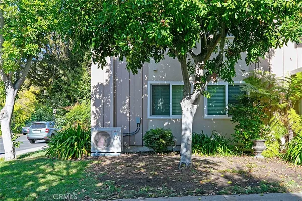 a front view of a house with a yard and tree