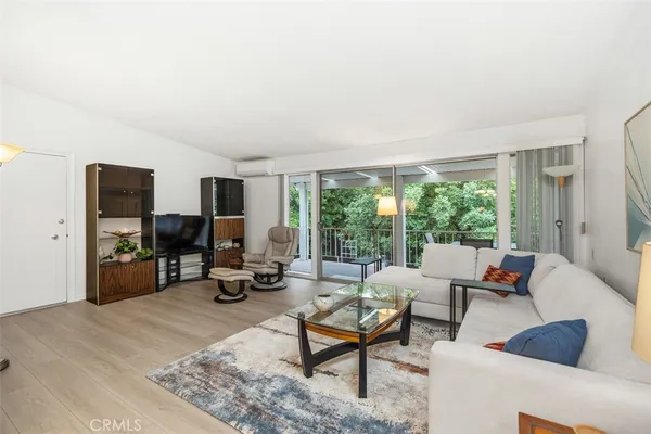 a living room with furniture and a flat screen tv with wooden floor