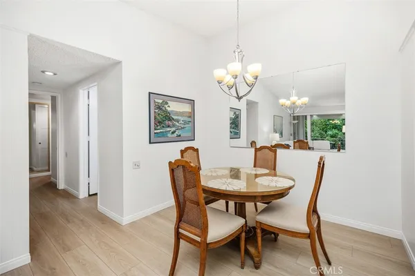 a view of a dining room with furniture a chandelier and wooden floor