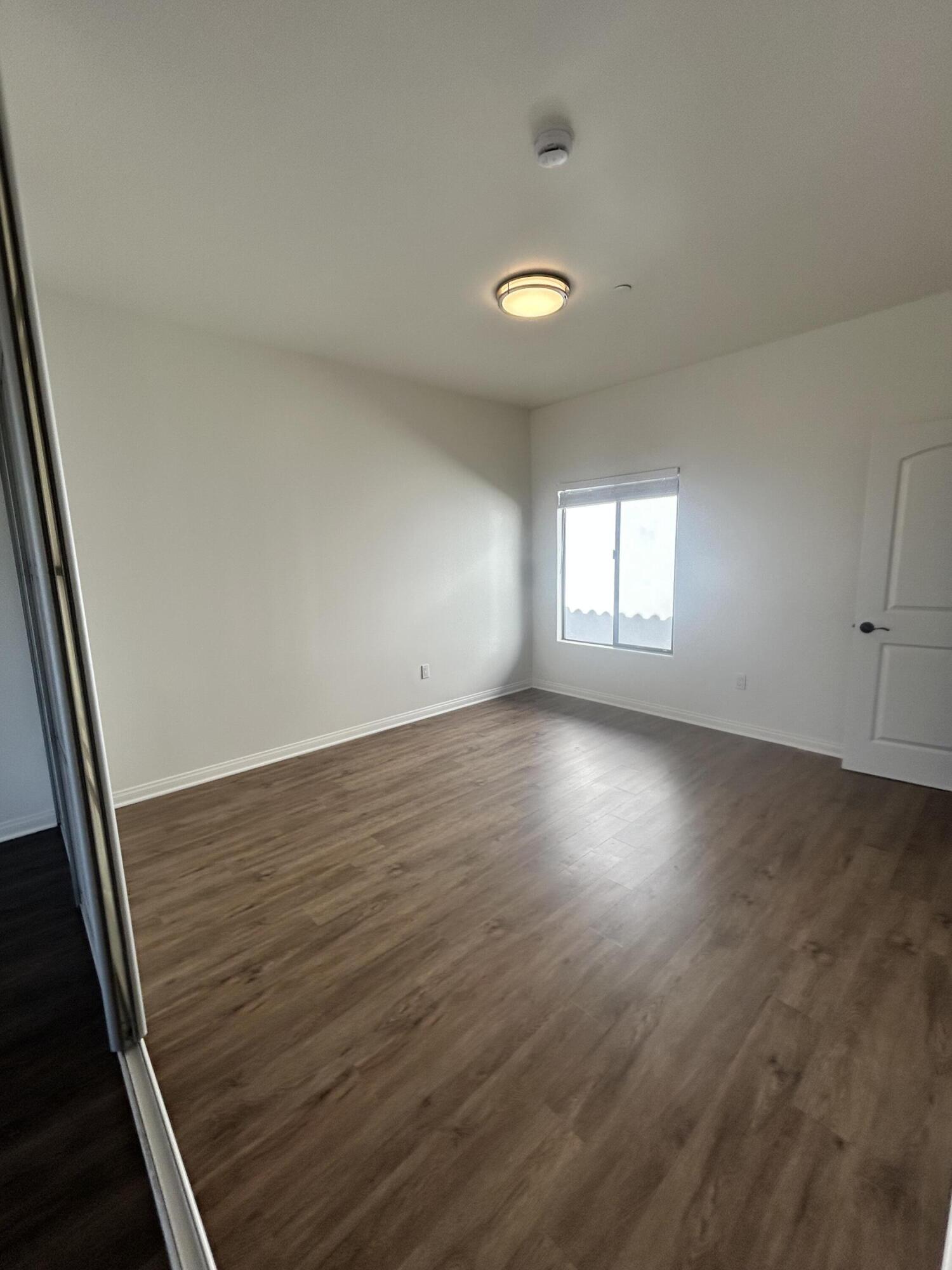920 Lowena Drive, Unit 9 Santa Barbara, CA 93103 - Photo 5 of 10 an empty room with wooden floor and windows