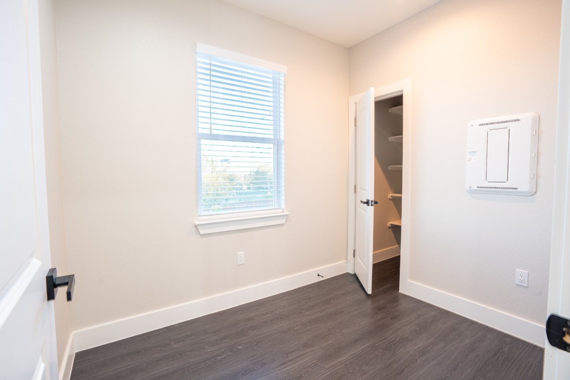 162 Meadow View Boulevard, Unit A Del Valle, TX 78617 - Photo 21 of 30 an empty room with wooden floor and windows