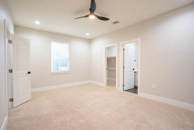 an empty room with closet and a chandelier fan