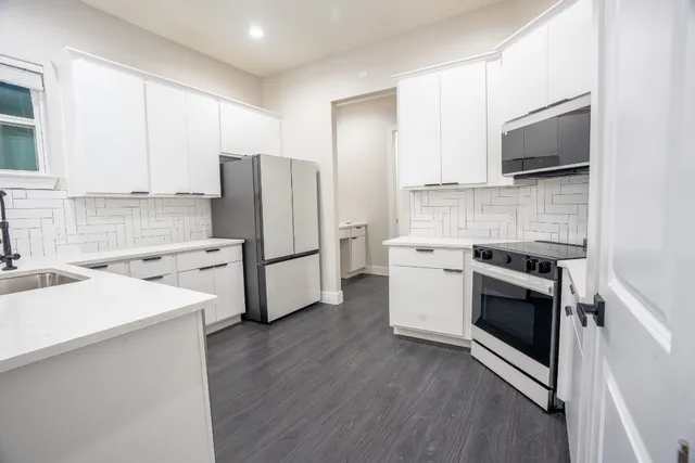 a kitchen with white cabinets and stainless steel appliances