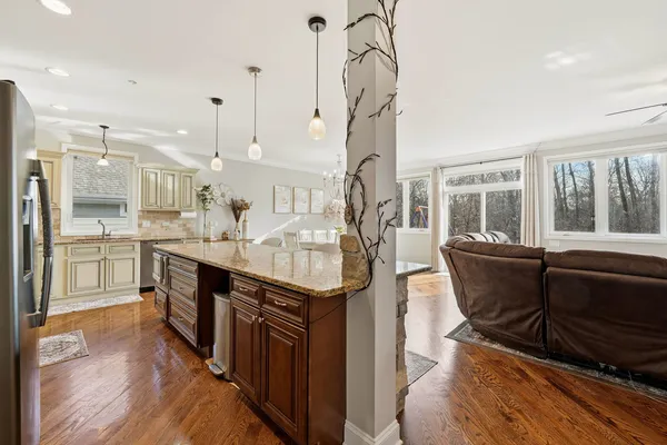 a kitchen with stainless steel appliances granite countertop a sink a stove and a wooden floors
