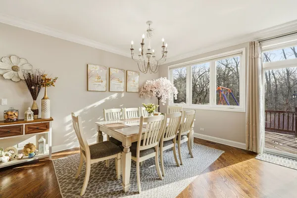 a view of a dining room with furniture a chandelier and wooden floor