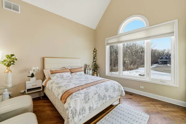 a bedroom with a bed and with a large window