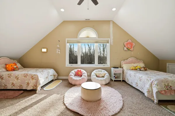 a spacious bedroom with two beds and a chandelier