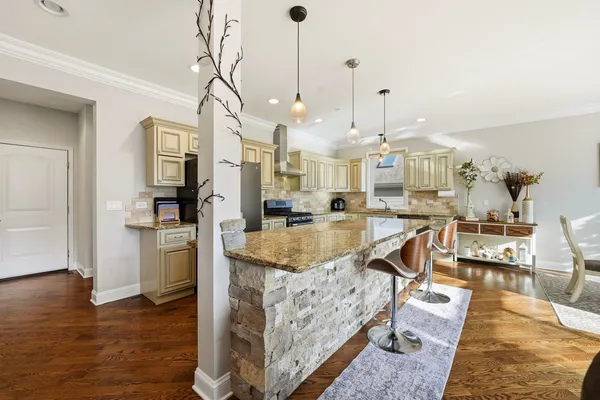 a very nice looking living room with kitchen and wooden floor