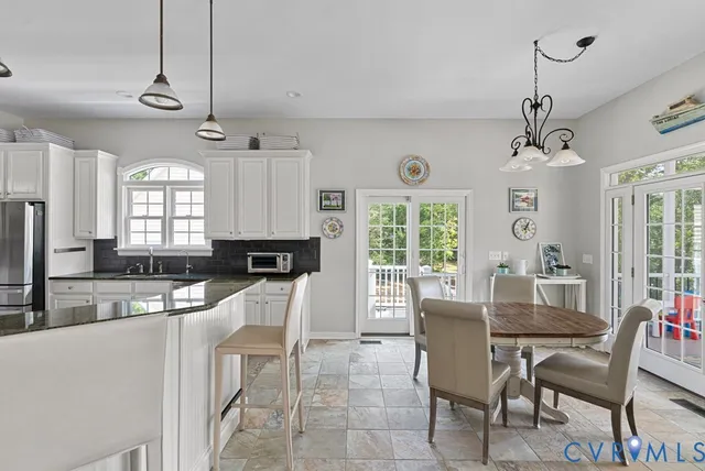 a dining room with wooden floor a chandelier a wooden table and chairs